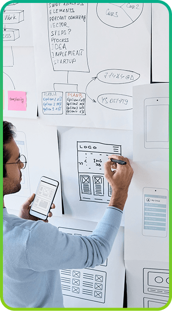 Persona dibujando wireframes en papel pegados a la pared
